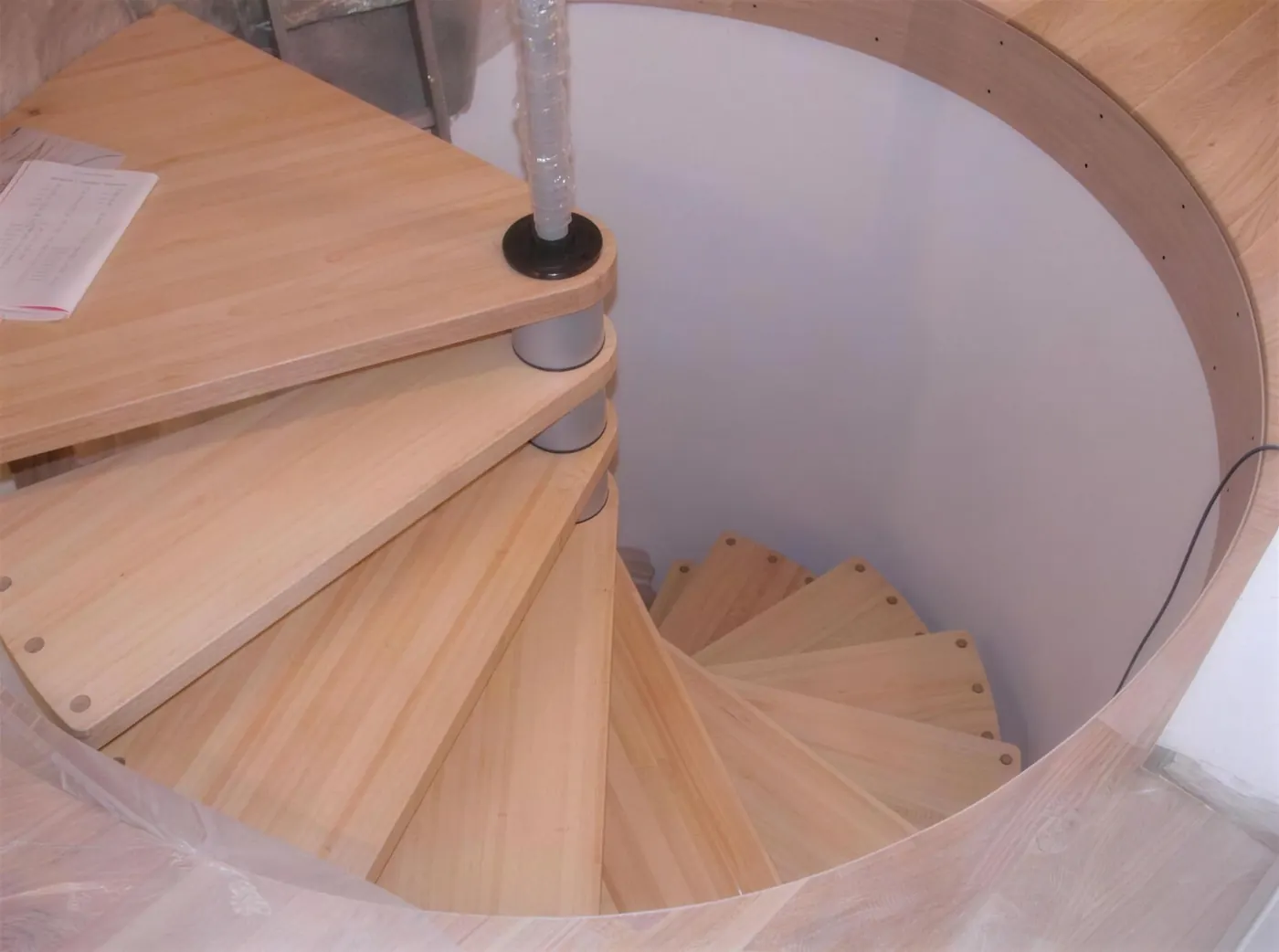 Handmade oak spiral staircase under construction in a round stairwell in a Cumbrian barn conversion