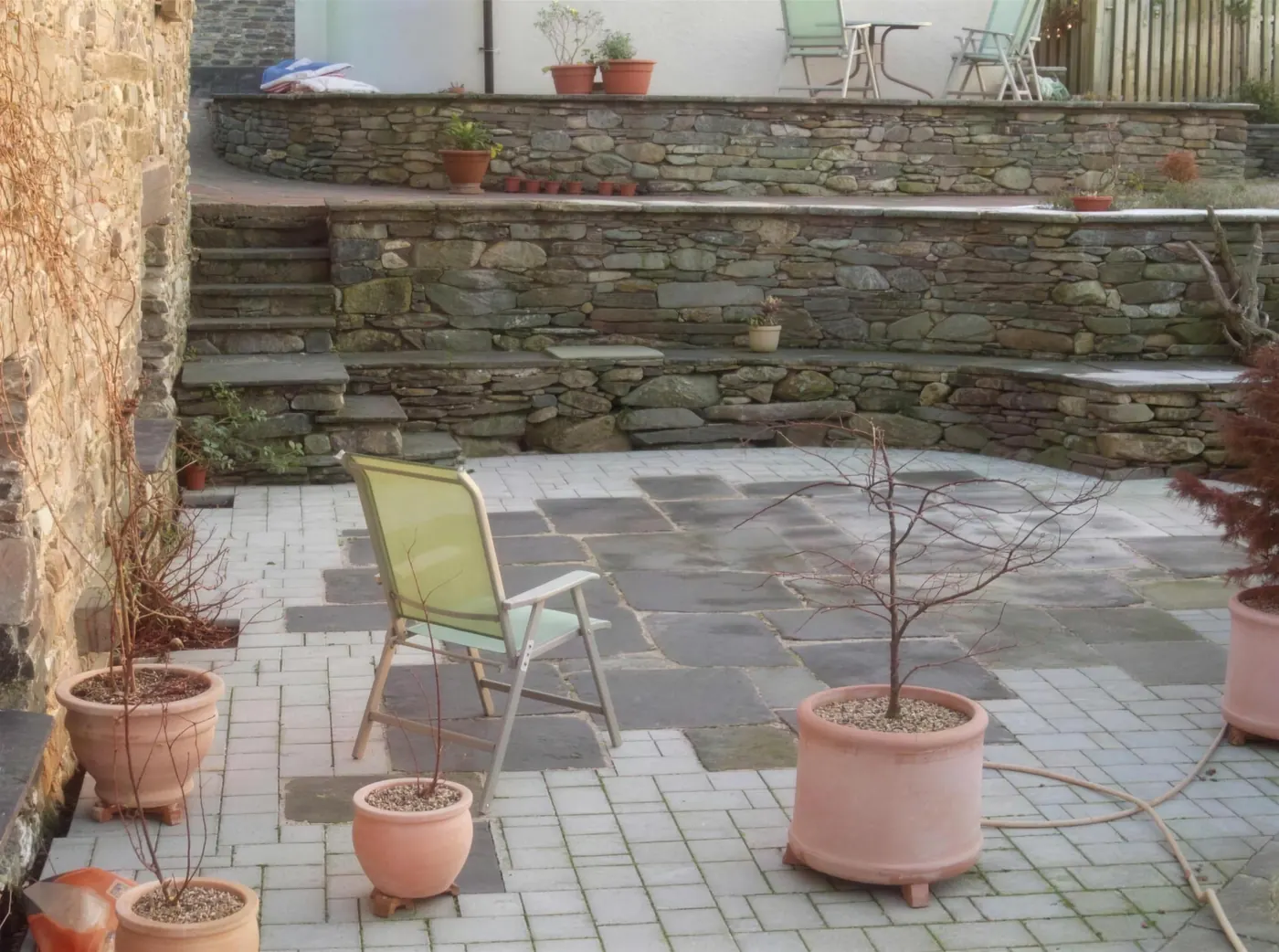 Slate paved outdoor area and stone wall built during a property improvement
