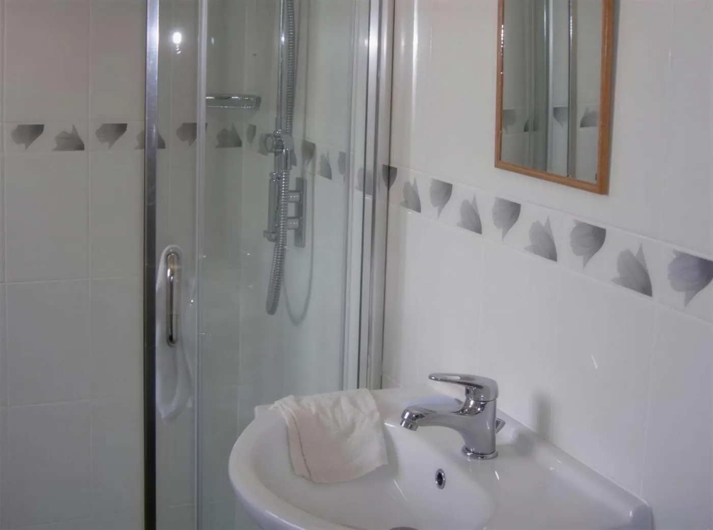 Compact tiled shower room with a glazed enclosure