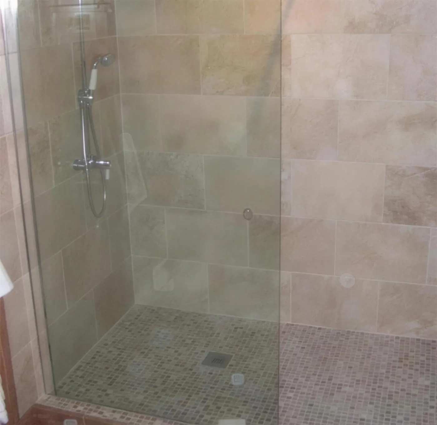 Natural stone tiled shower area with a glazed screen